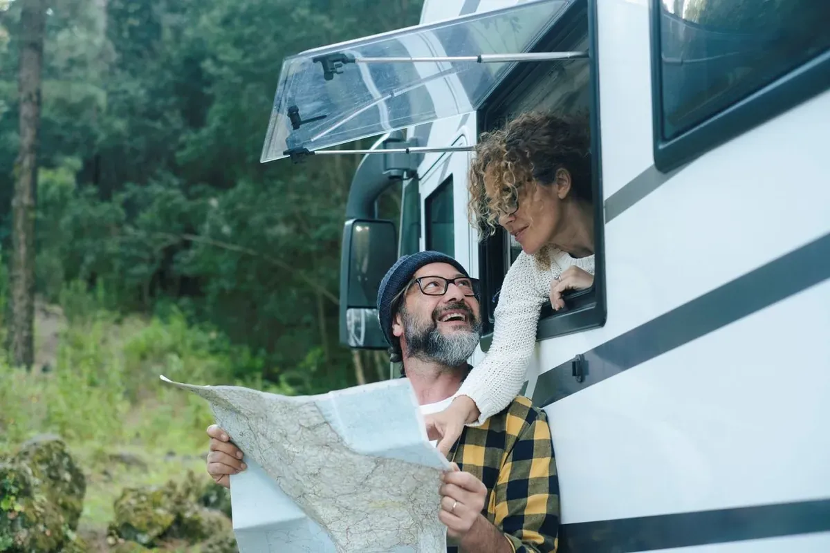 A man and woman using a map to choose their next travel destination.